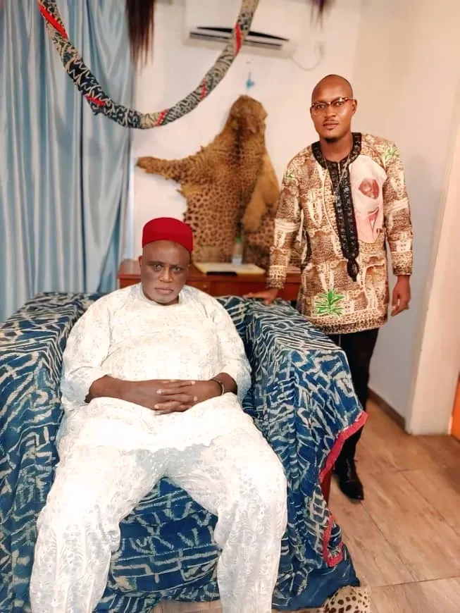 Joseph Kuika, président du FMPN, au côté de Sa Majesté le chef supérieur, roi des Bangangté, assis sur un trône recouvert de ndop, peau de léopard au mur