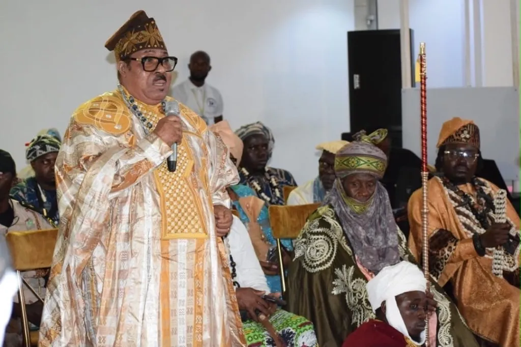 Orateur en agbada orné s’adressant à une assemblée de chefs et d’aînés