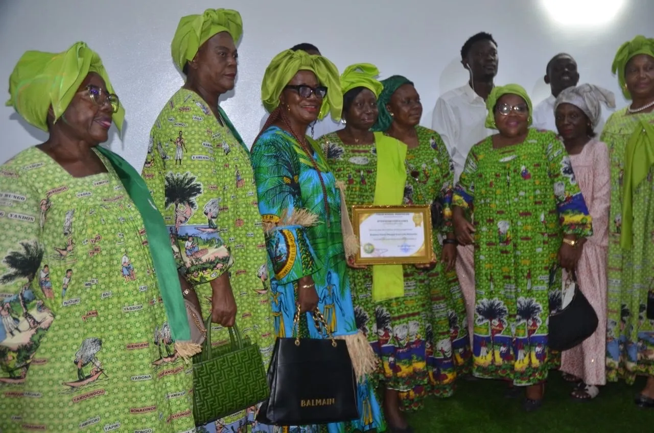Groupe de femmes en tenues vertes assorties tenant une attestation d’excellence